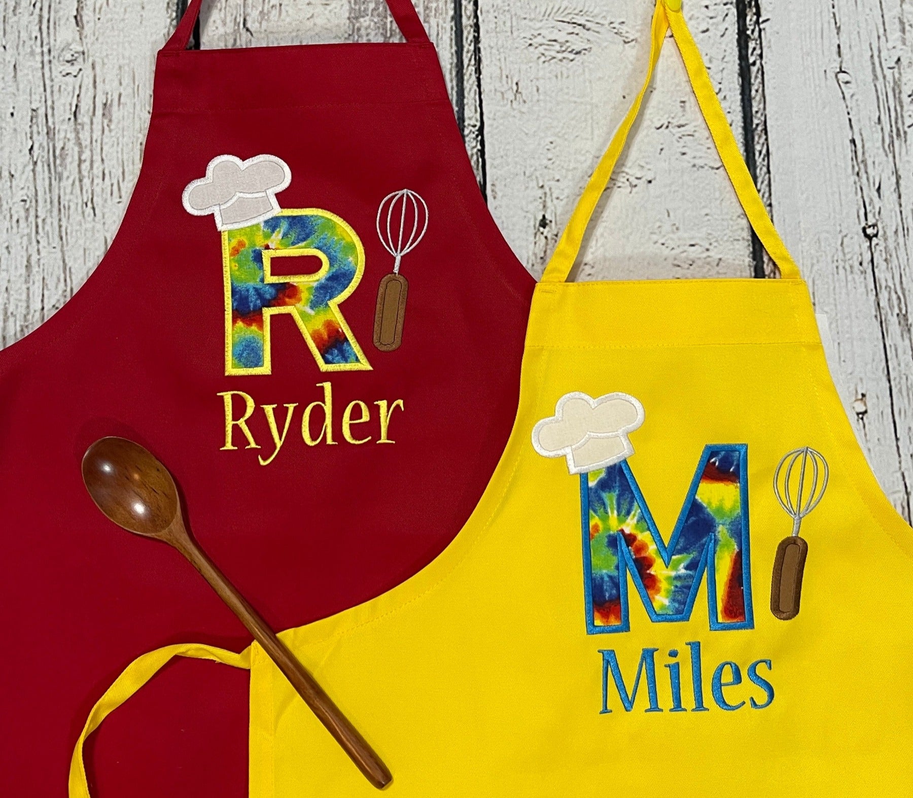 Kids personalized aprons one red one yellow with embroidered name and tie dye fabric
