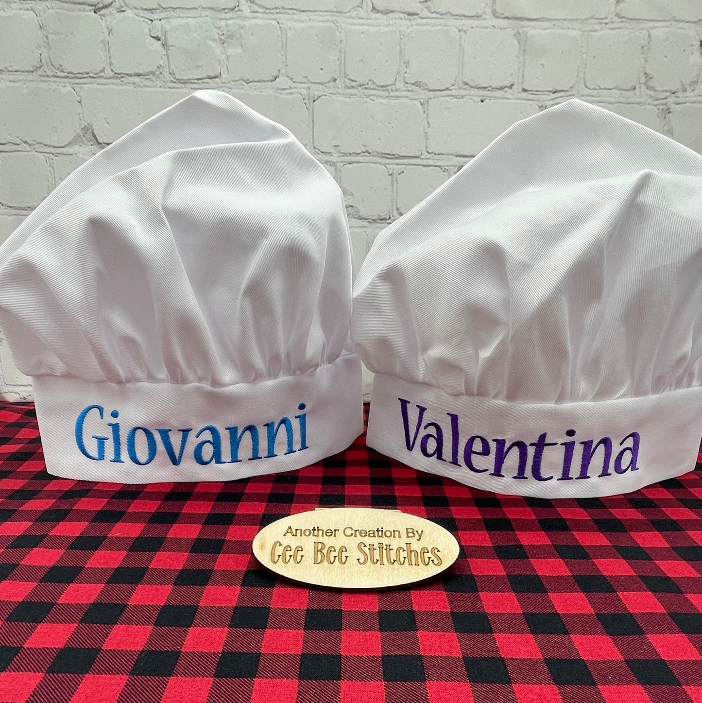 White chef hats with embroidered names in blue and purple