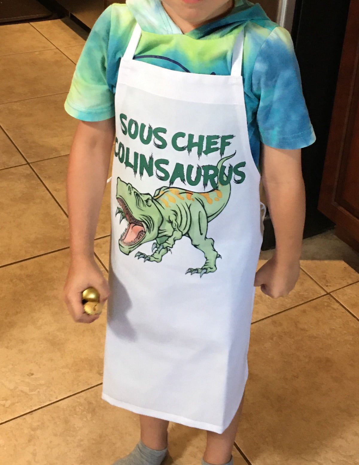 child wearing dino apron