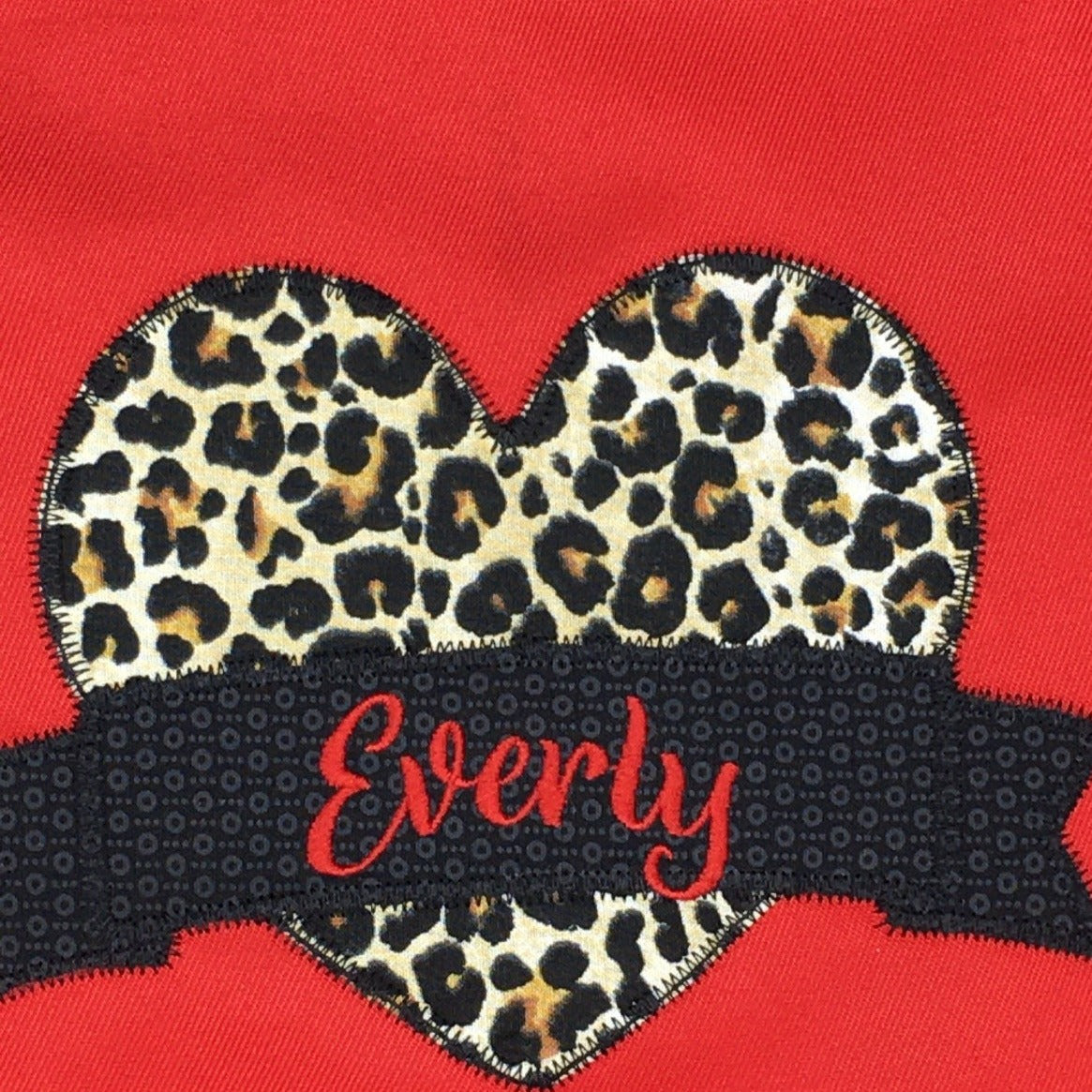 Girls red apron animal print with name closeup